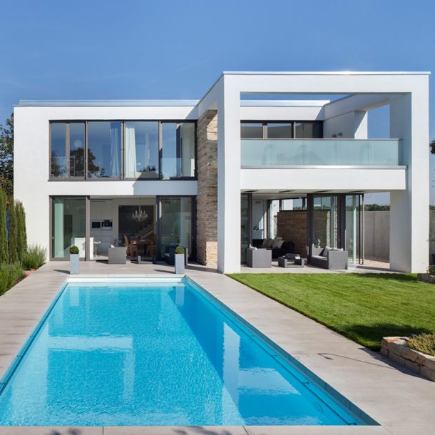 Modernes Geb&auml;ude mit Pool im Vordergrund